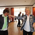 Zwei Seniorinnen tanzen und lachen