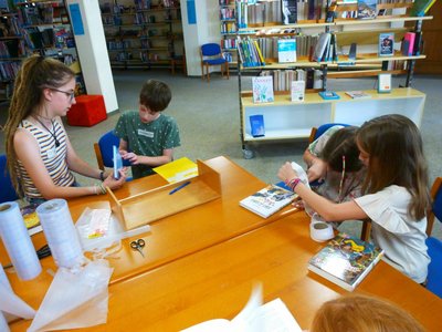 Mit höchster Konzentration binden die Kinder ihre Bücher in Folie ein.