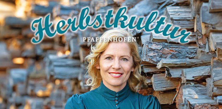 Titel der Herbstkultur; Frau in blauer Bluse, im Hintergrund geschlichtetes Holz