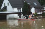 Boot der Feuerwehr Pfaffenhofen mit zwei Männern im Einsatz bei Hochwasser zwischen Häusern