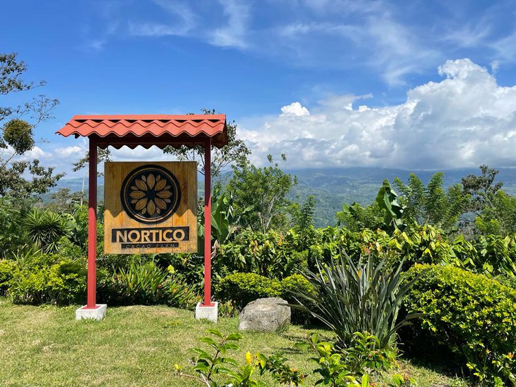 Logo der Kakaofarm Nortico auf einem Hügel vor der Landschaft von Rosta Rica